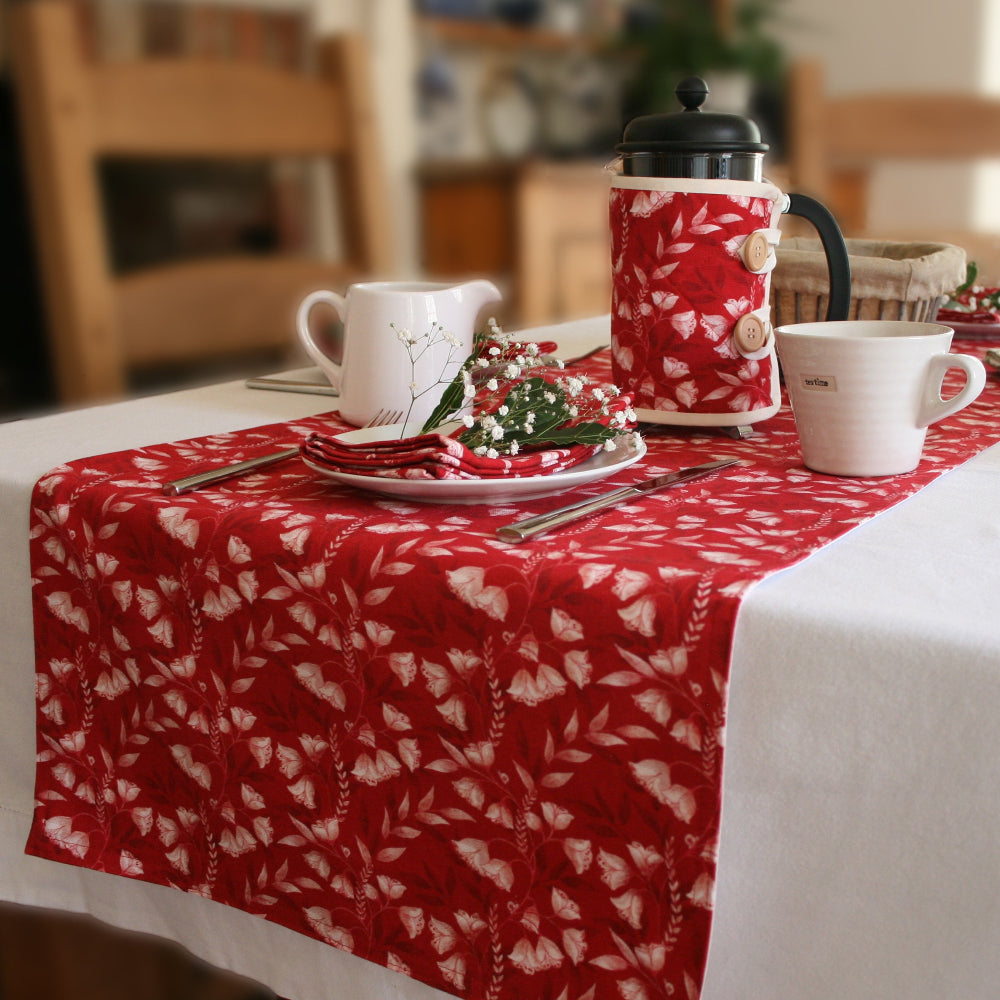 Red floral table runner, place setting with white mug and ug