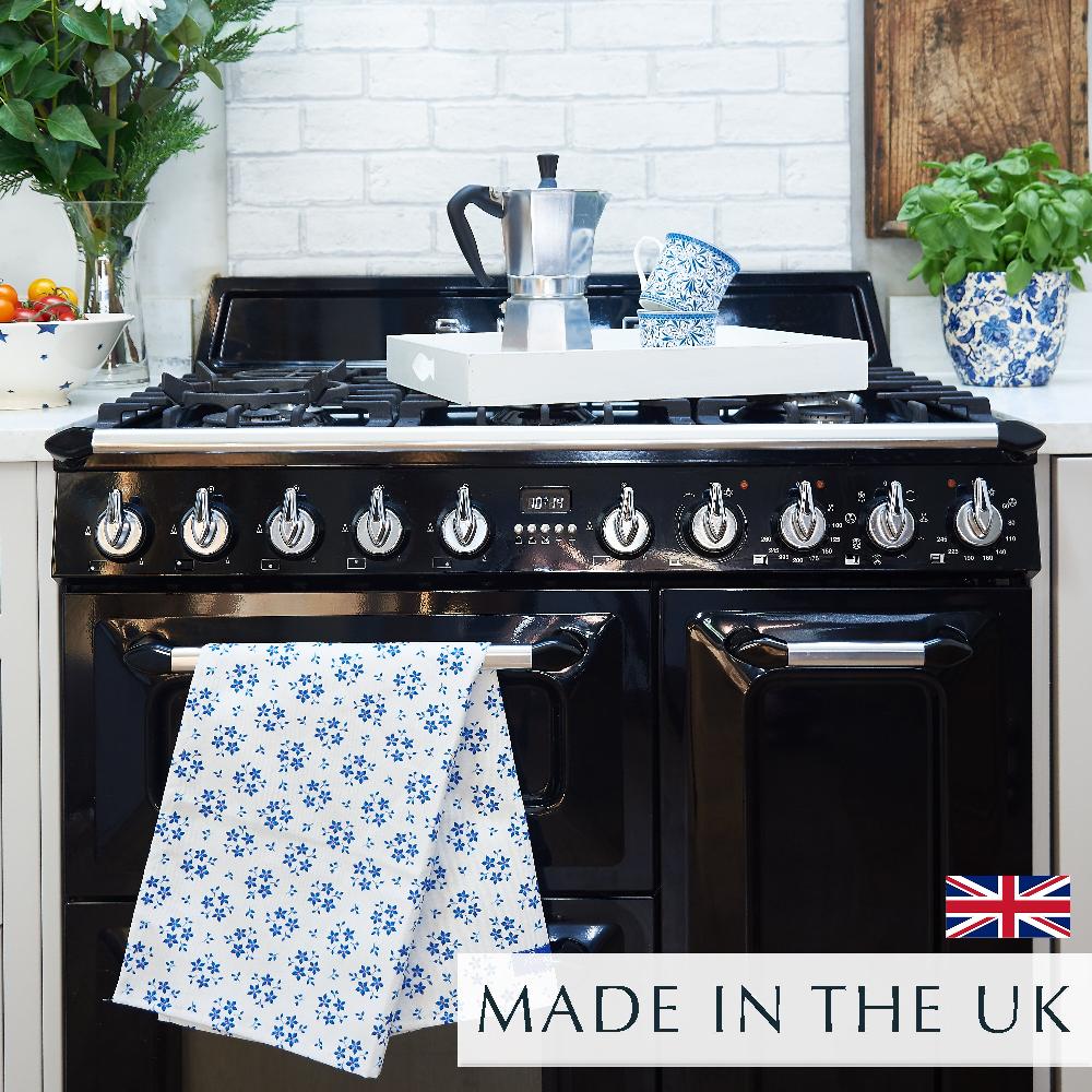Chez Beccy Blue Ditsy Floral Tea Towel on black range cooker with a tray with coffee pot and blue and white china mugs
