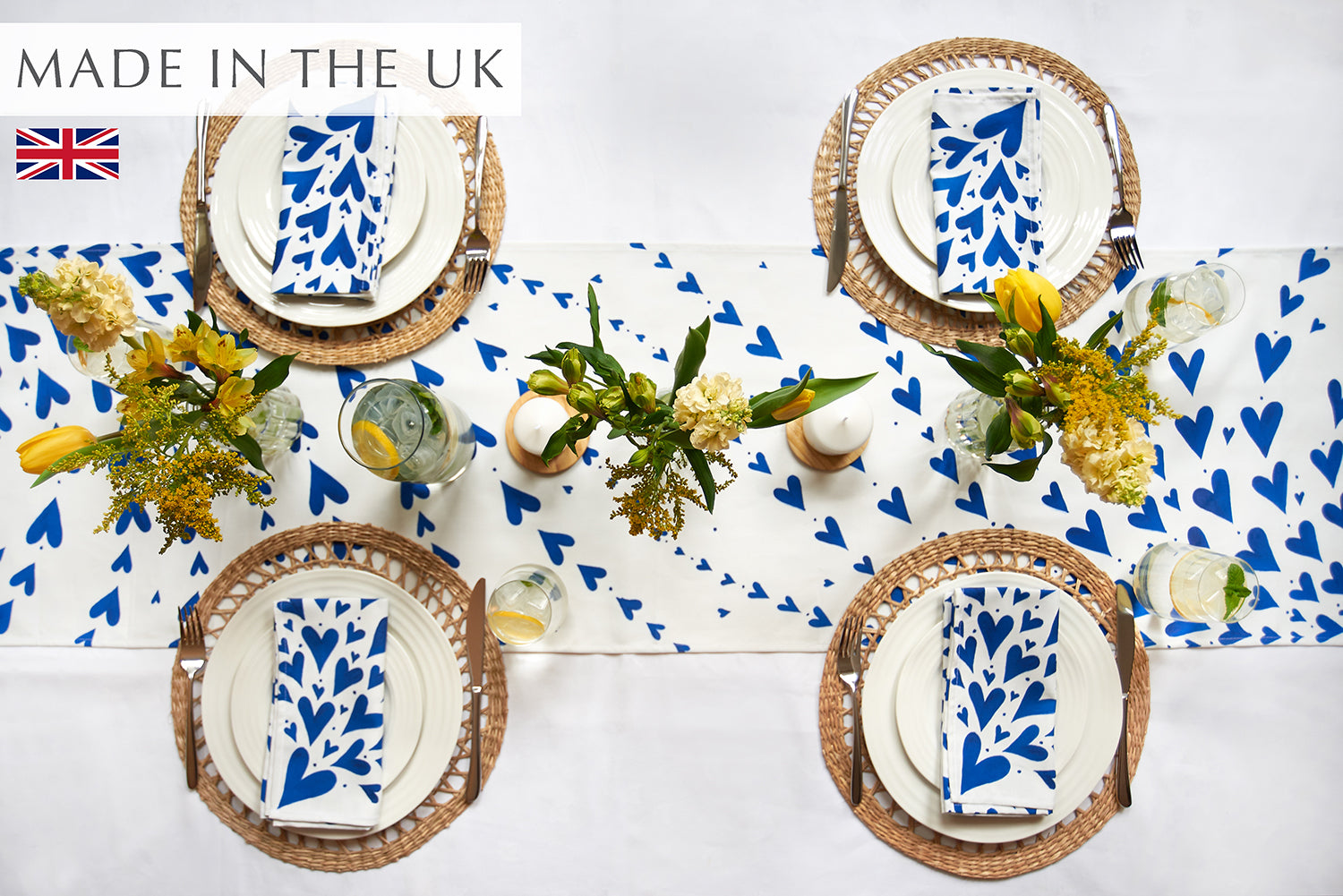 Blue hearts table runner on a white cloth with 4 place settings