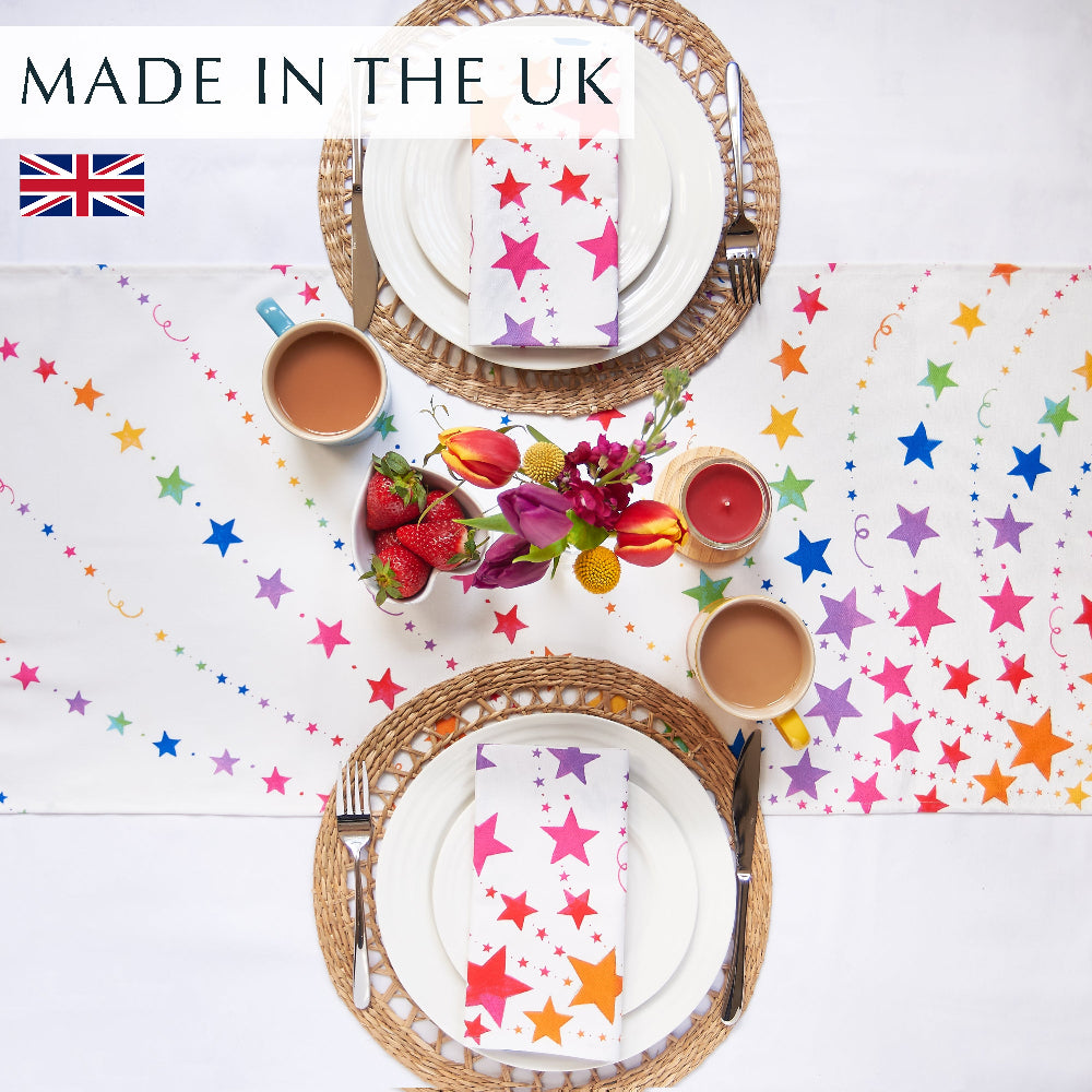 Rainbow stars table runner wit 2 place settings , flowers and cups of tea