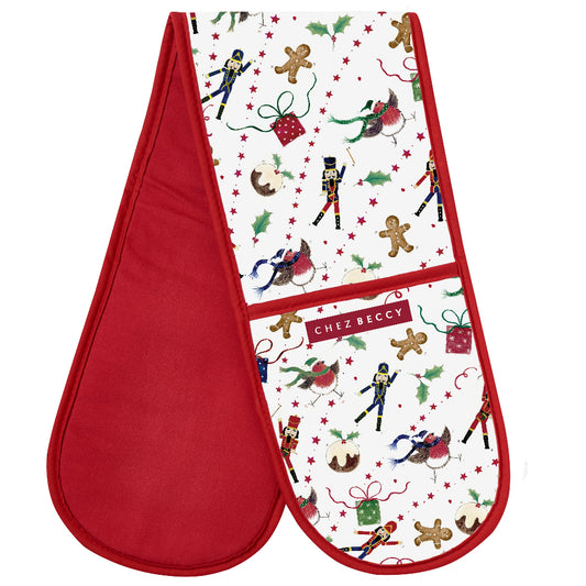 A double oven glove with a red background featuring a Christmas-themed pattern with Santa, reindeer, and holiday decorations. The glove is lined with a polyester thermal layer and has a red piping detail around the edge.