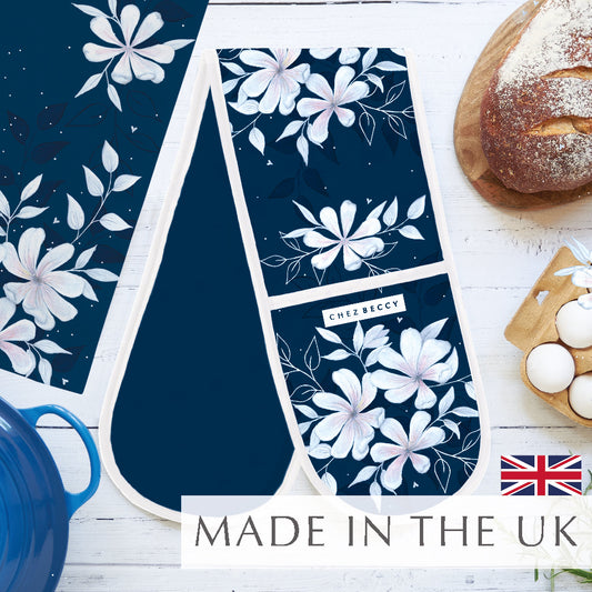 Navy Magnolia Floral Double Oven Glove with cream trim, styled with bread, eggs, and a blue pot – British-made kitchen textile by Chez Beccy