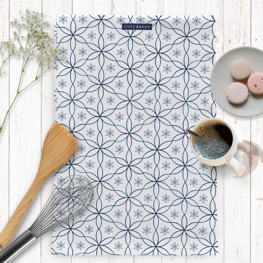 A beautifully designed Navy Daisy Tea Towel featuring an elegant geometric floral pattern in deep navy blue. Made from 100% half panama cotton, this absorbent and stylish kitchen towel is perfect for drying dishes and adding a decorative touch to any home. Designed and made in the UK.