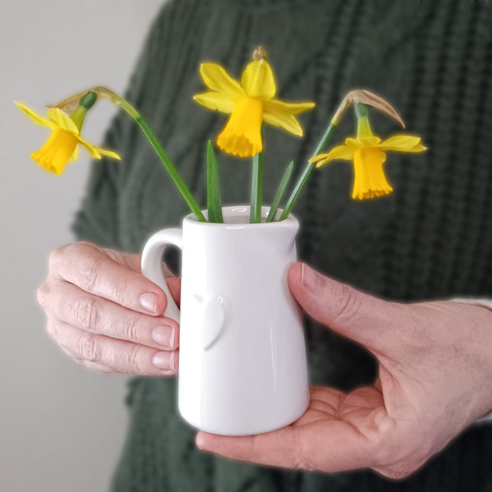 A stylish and cute ceramic white heart jug with miniature daffodils, the perfect gift for mum, for Mother's day