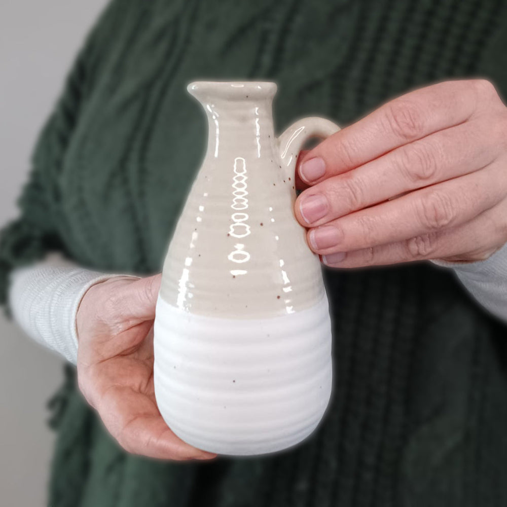 Chic two-tone ceramic jug with a natural beige and white finish, featuring a delicate handle and subtle speckled texture. Perfect for dried flowers, fresh stems, or as a rustic home décor piece. A great gift for Mother's Day or housewarming.