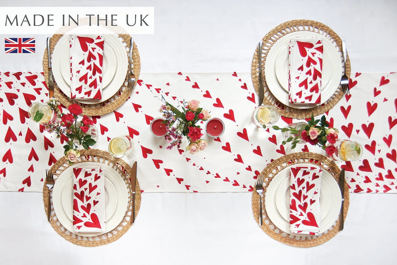 Red hearts table runner on a white cloth with 4 place settings