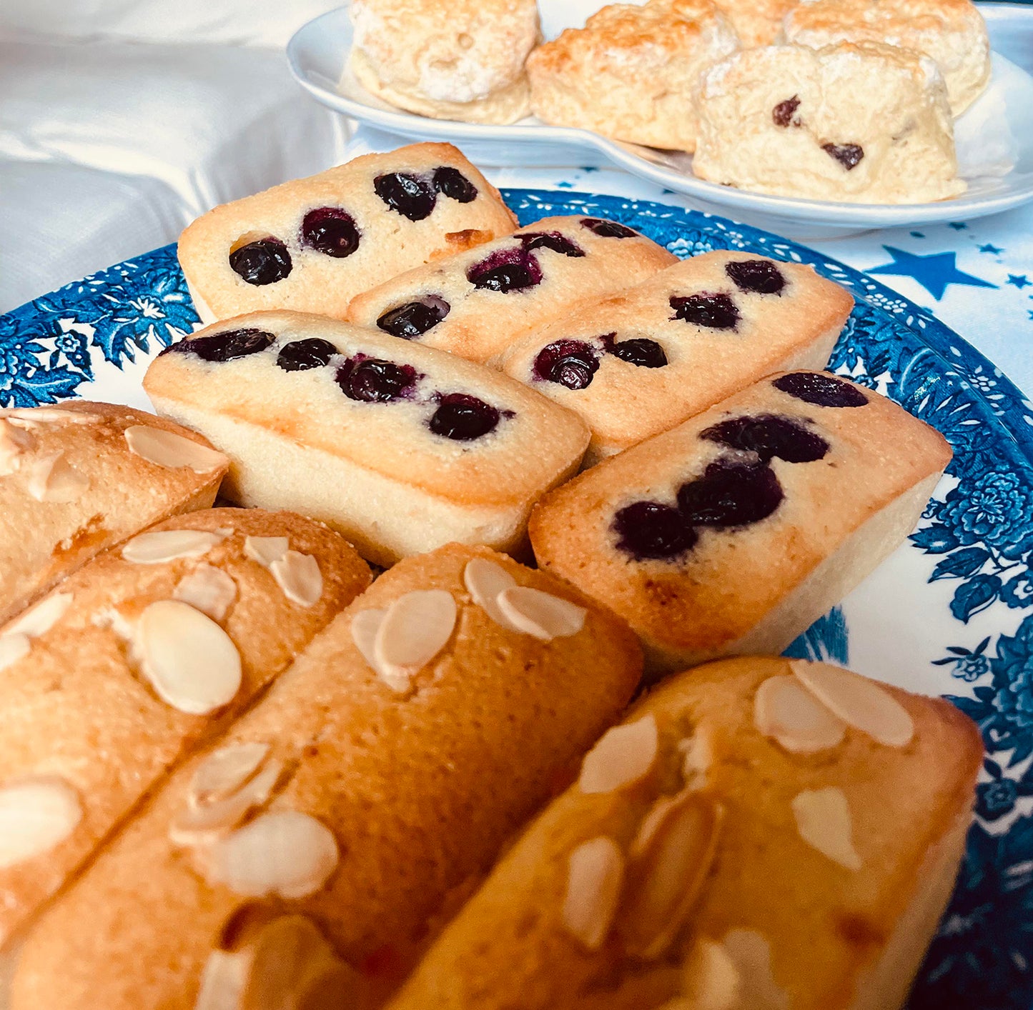  a plate of blueberry and plain almond financiers