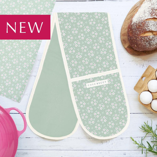 Green ditsy floral double oven gloves with a loaf of bread, eggs and a pink casserole dish