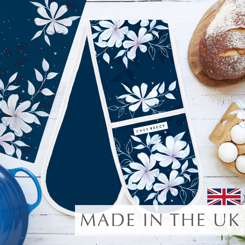 New navy double oven glove with large floral design on a white wooden background with baking props