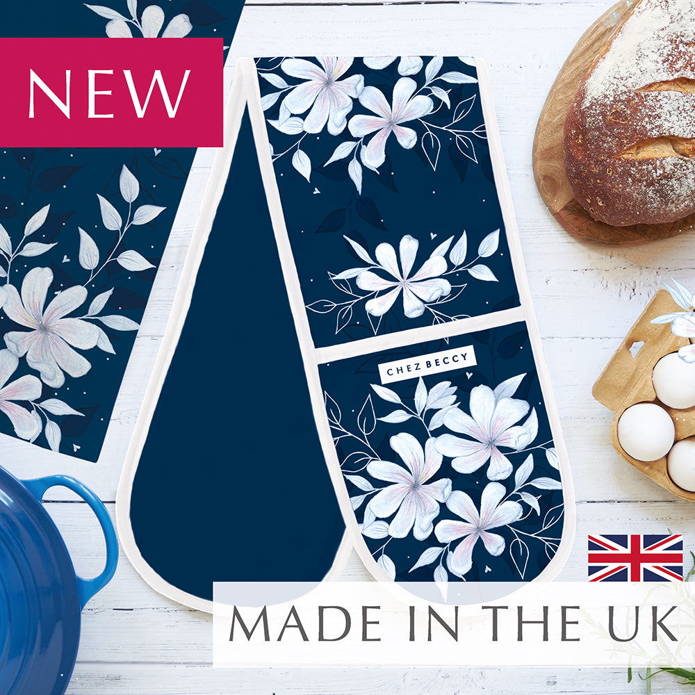 New navy double oven glove with large floral design on a white wooden background with baking props