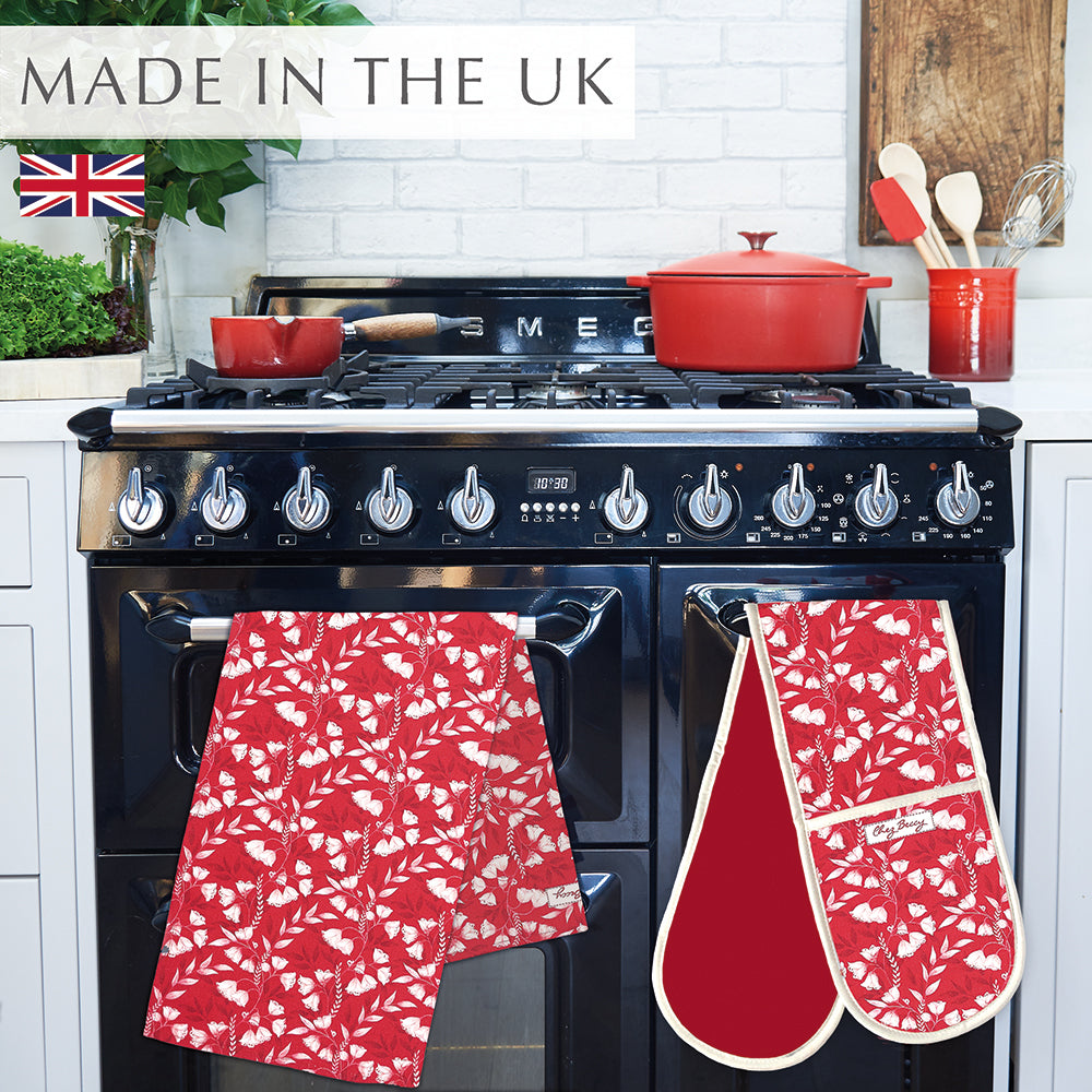 Red Floral Tea Towel in 100% half panama cotton, with delicate floral design and soft, vibrant colours, perfect for the kitchen. Hanging on  black range cooker with matching double oven glove.