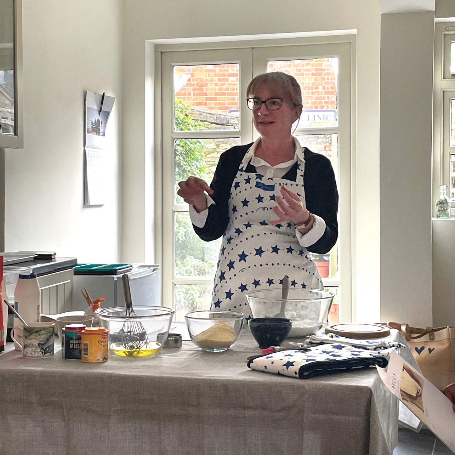 Cook Beccy standing at a table mid baking demonstration