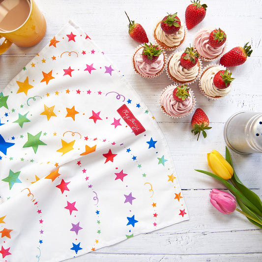 A 100% cotton tea towel featuring a vibrant spray of multicoloured stars, adding a cheerful touch to any kitchen. Measuring approximately 70cm x 47cm, it's both absorbent and stylish. Designed and made in the UK.